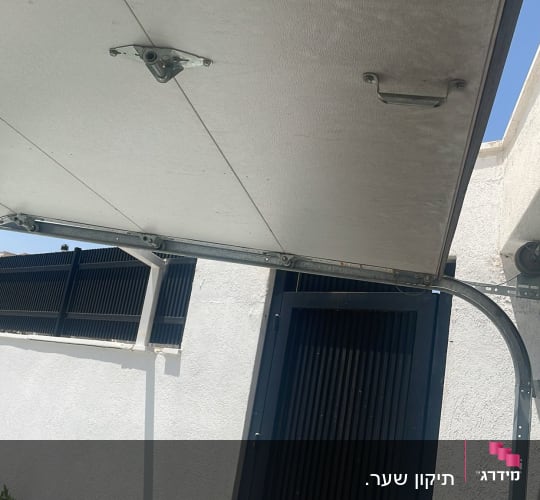 שער חשמלי פתוח עם מסגרת מתכת ומנגנון קפיצים